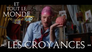 homme tenant un faux cerveau rose dans sa main avec un bonnet de piscine rose, un casque et des lunettes